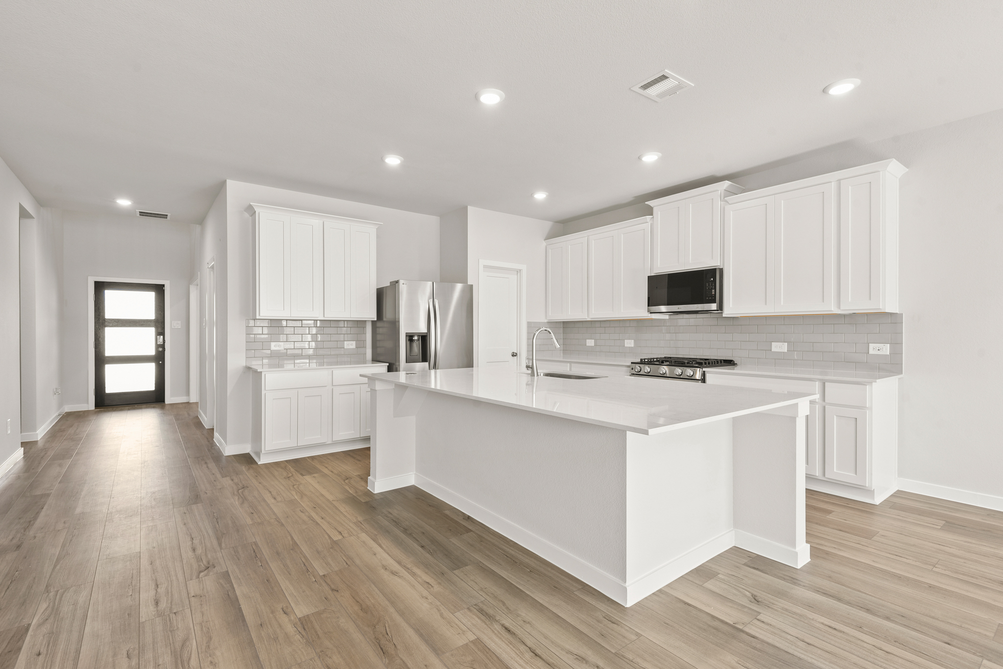 A kitchen with white cabinets.