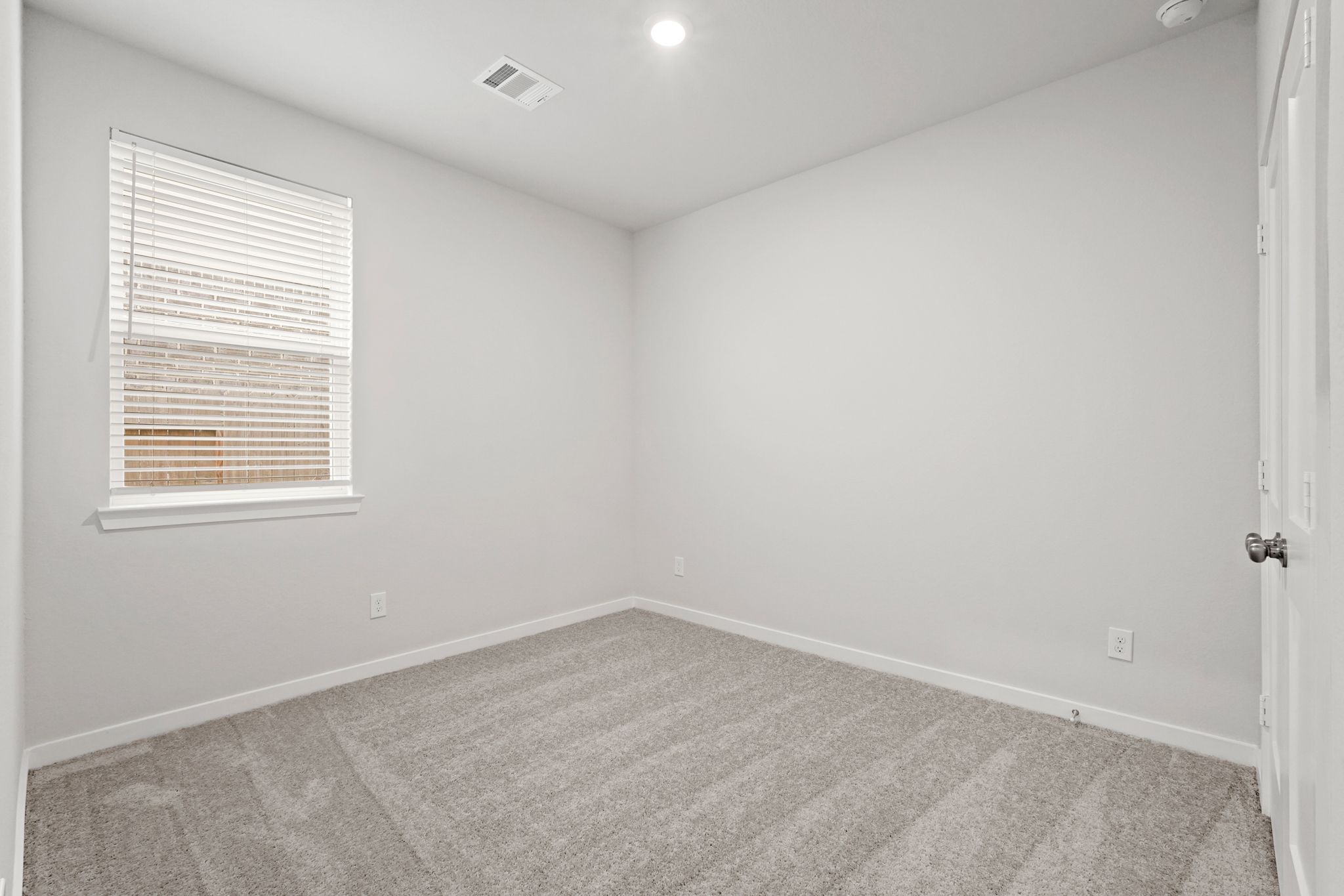 A room with a carpet and a window.