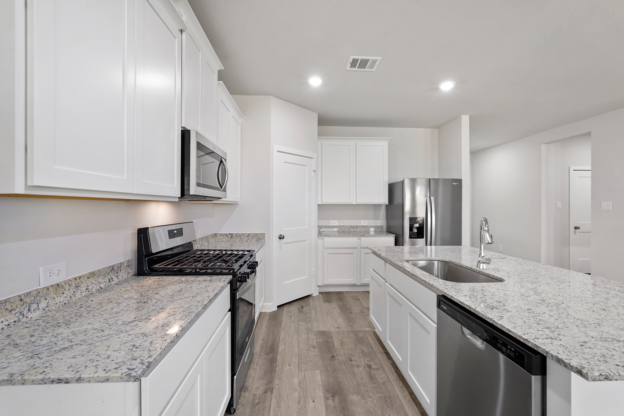 A kitchen with white cabinets.