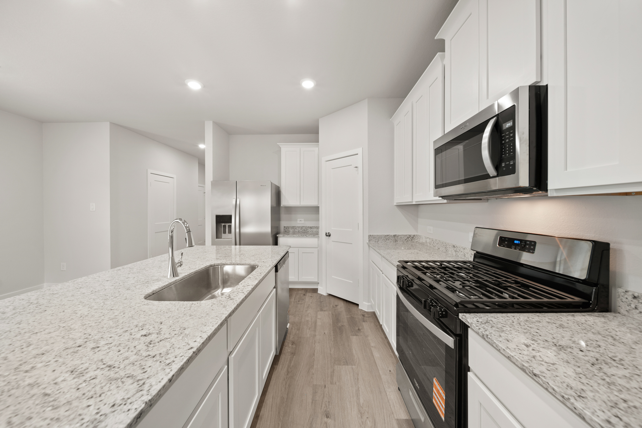 A kitchen with white cabinets.