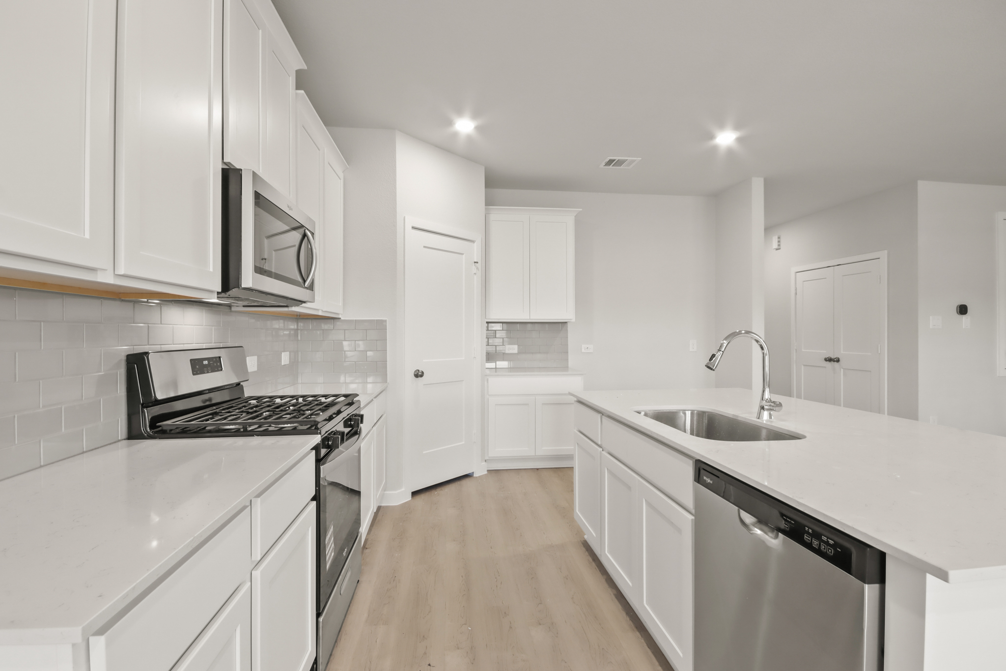 A kitchen with white cabinets.