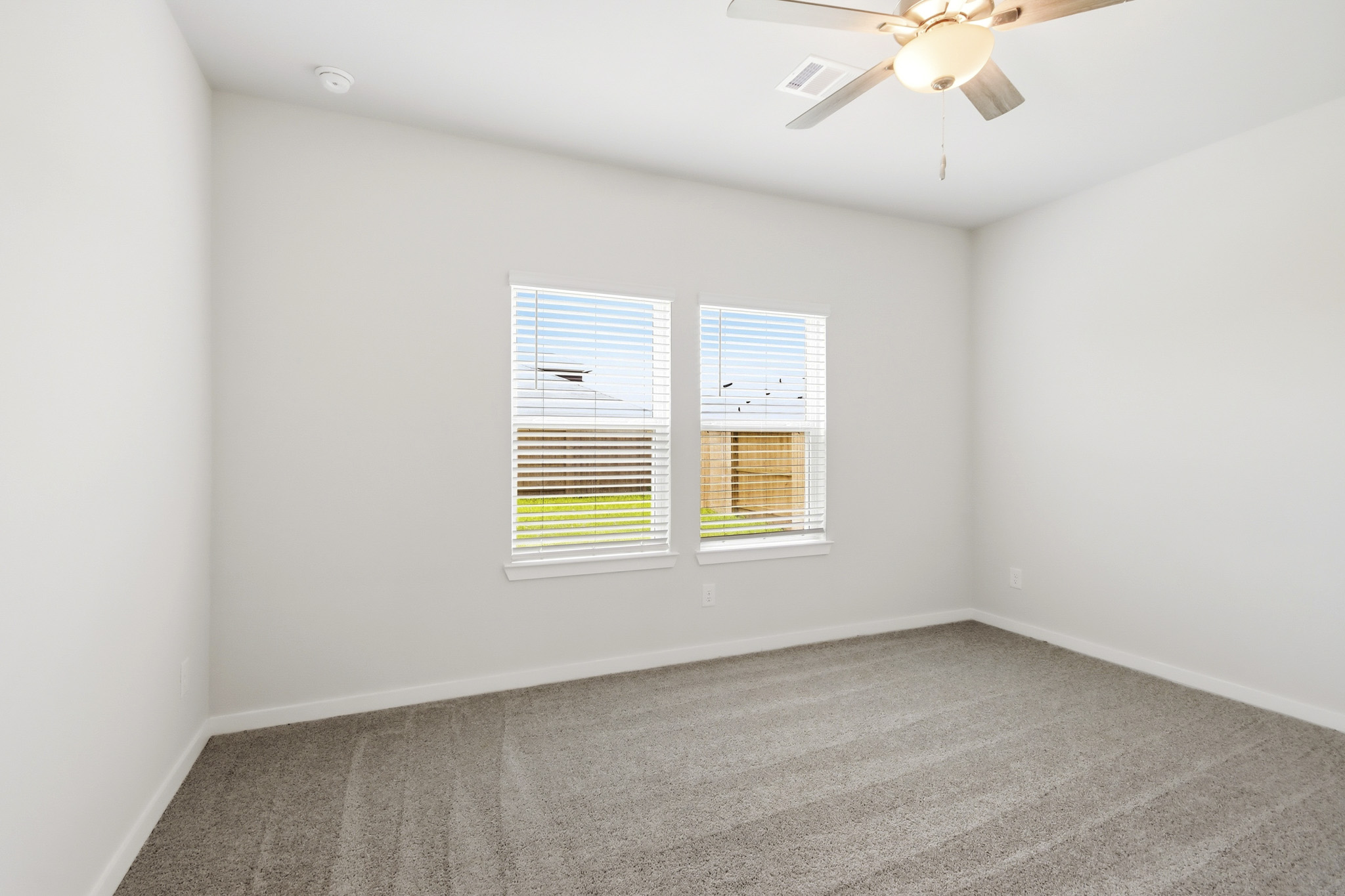 A room with a ceiling fan and a window.