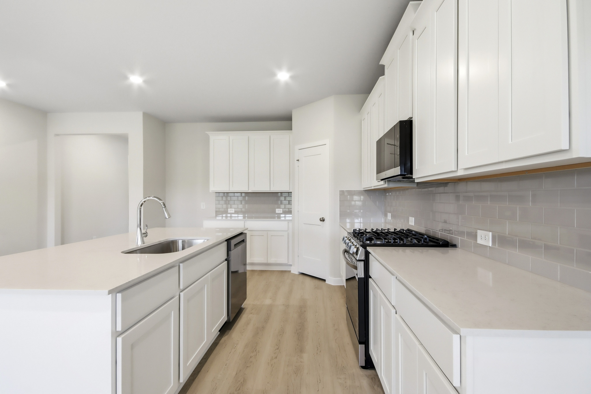 A kitchen with white cabinets.