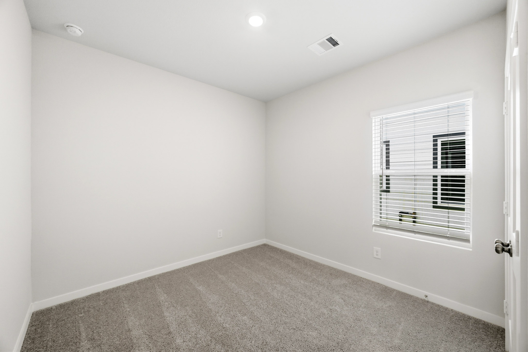 A room with a window and a carpet.