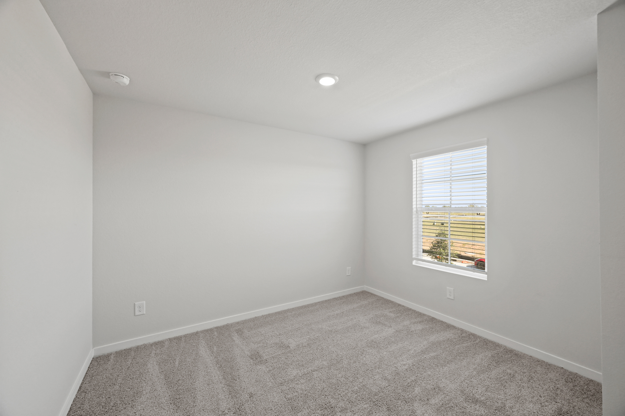 A room with a window and a carpet.