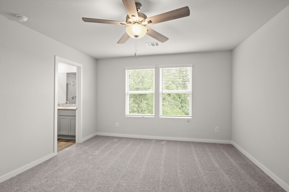 A room with a ceiling fan and a window.