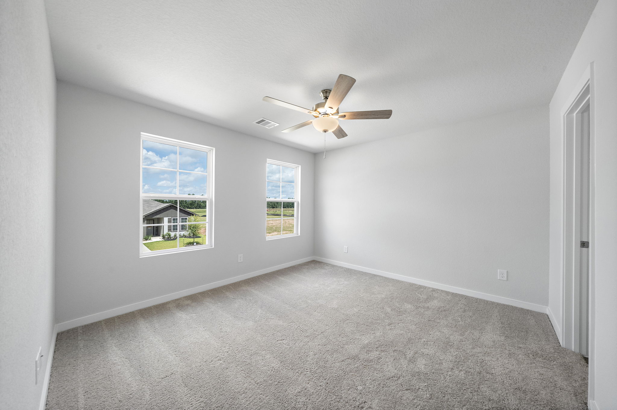A room with a ceiling fan and a window.