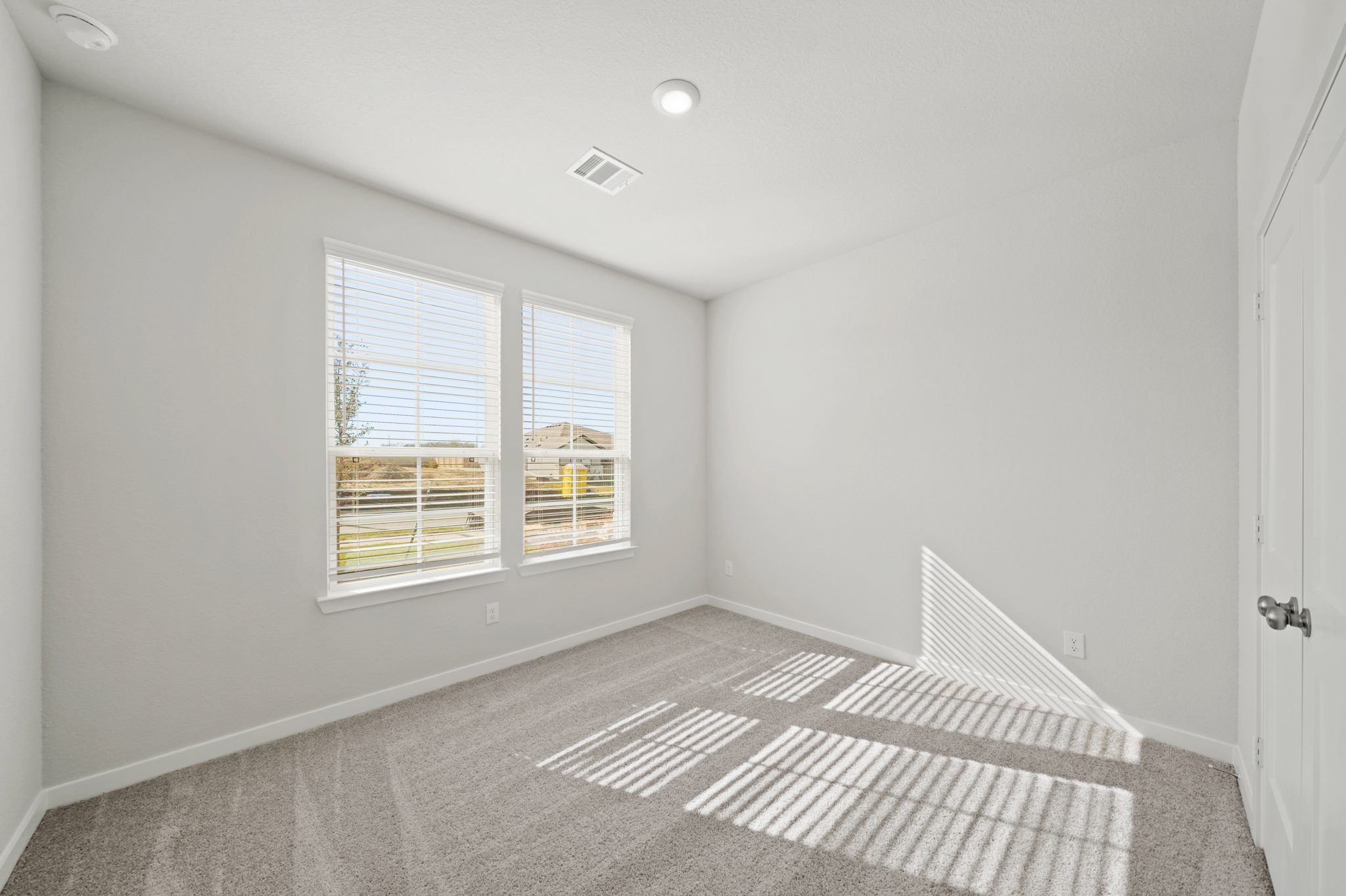 A room with a rug and a window.