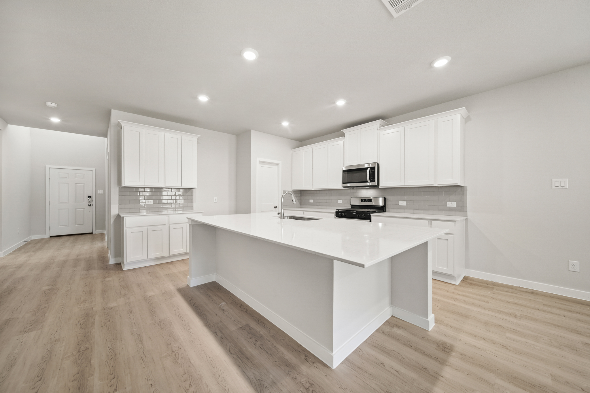 A kitchen with white cabinets.