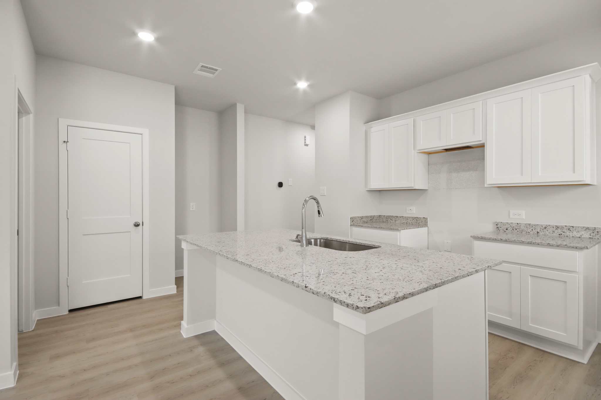A kitchen with white cabinets.