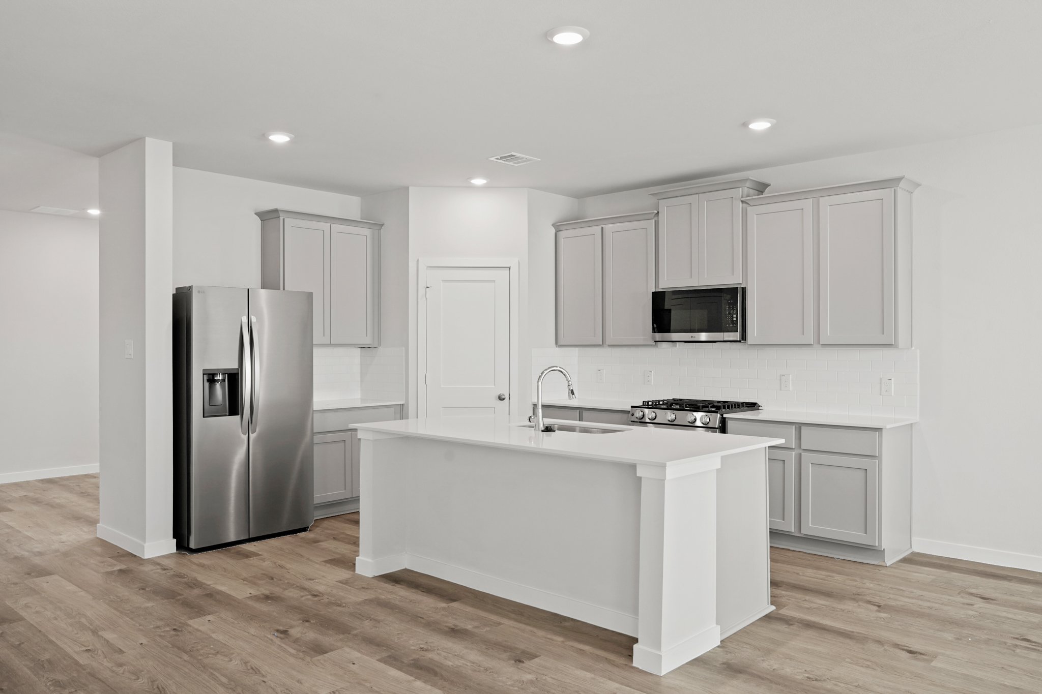 A kitchen with white cabinets.