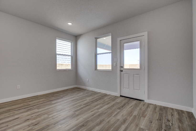 A room with a wood floor and a white door.