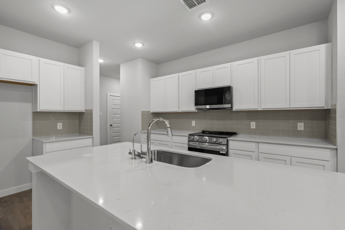 A kitchen with white cabinets.