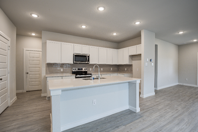 A kitchen with white cabinets.
