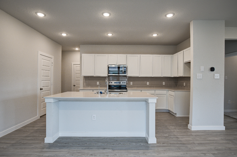 A kitchen with white cabinets.