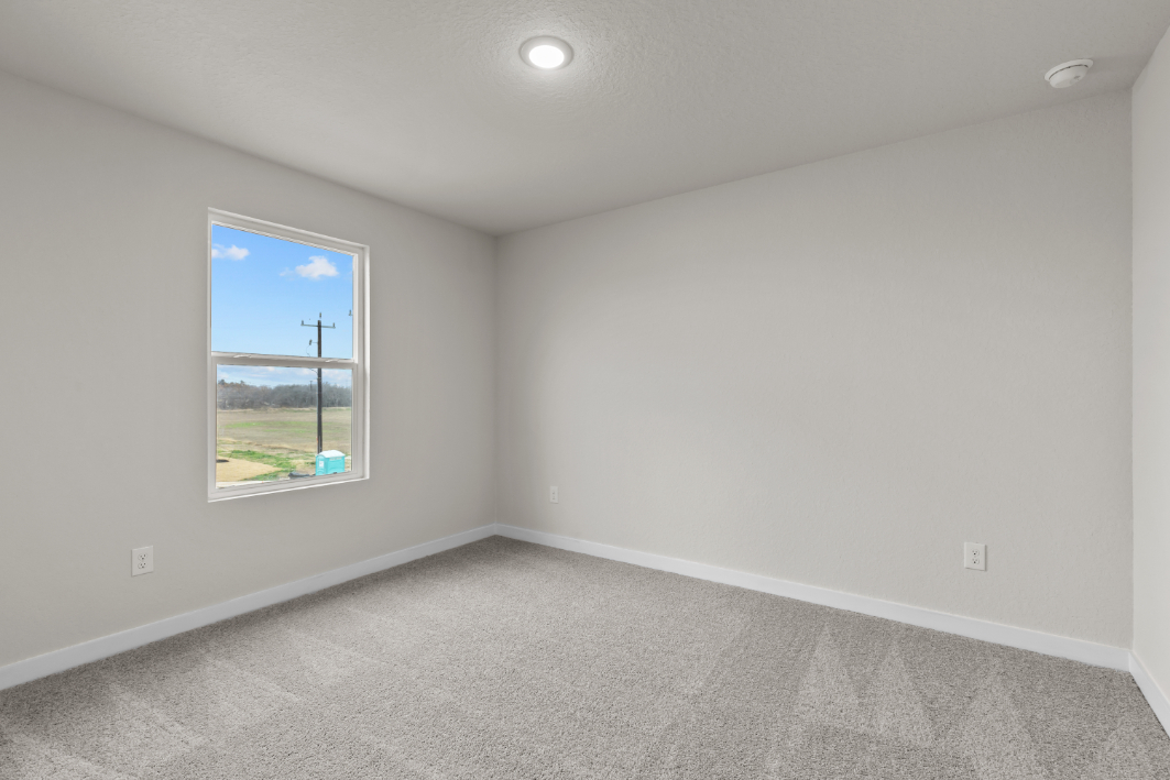 A room with a window and a carpet.