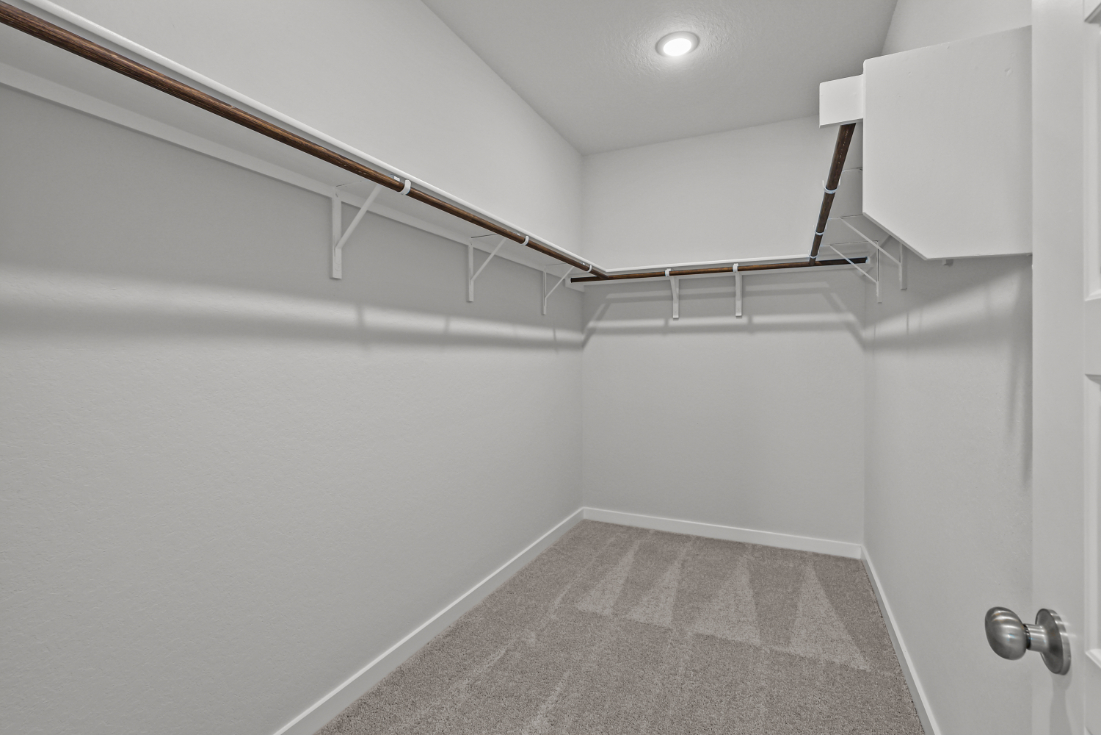 A white hallway with a metal railing.