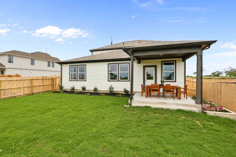 A house with a fence and lawn.