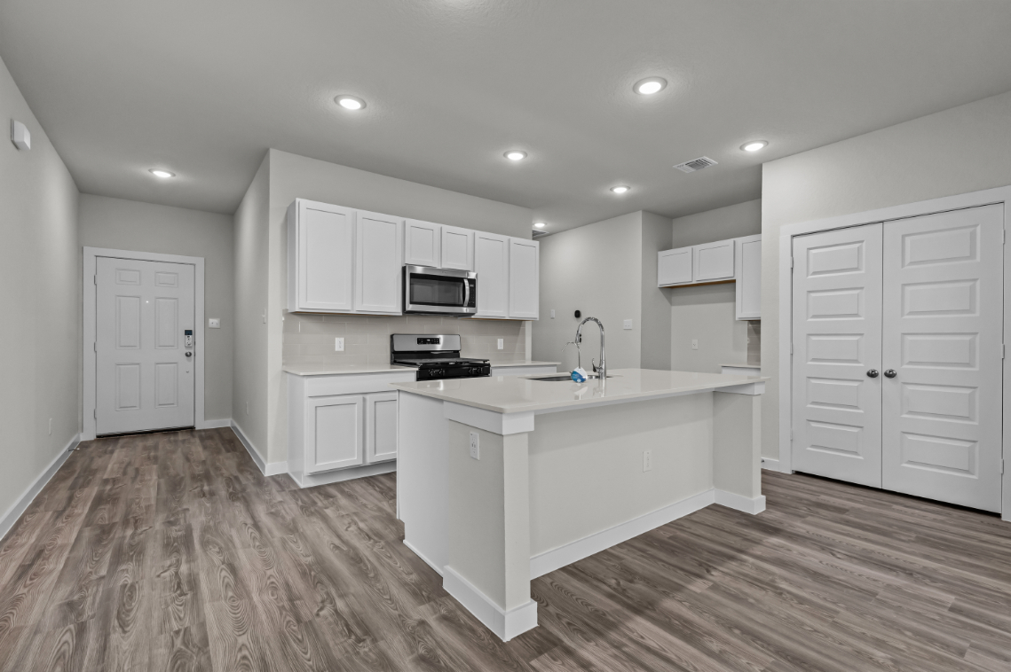 A kitchen with white cabinets.