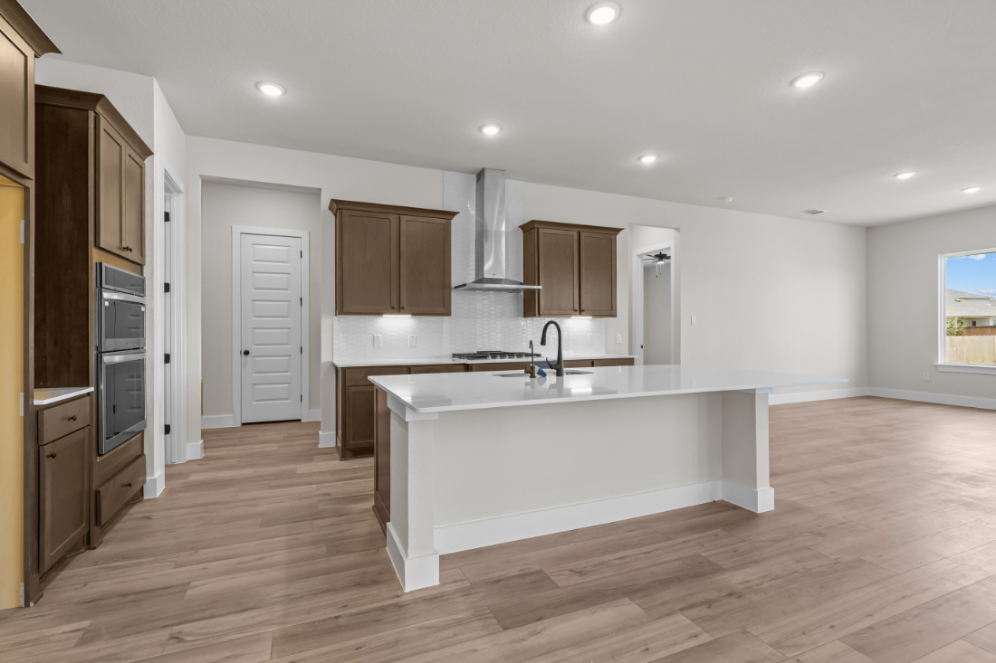 A kitchen with a tub and cabinets.