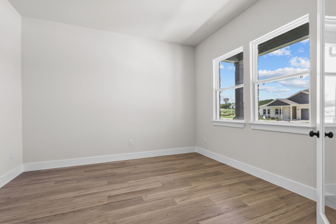 A room with a wood floor and windows.