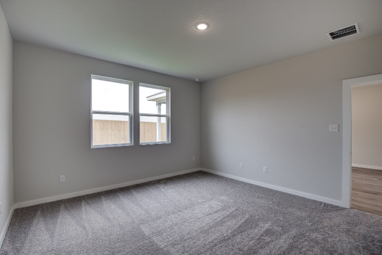 A room with a carpet and windows.