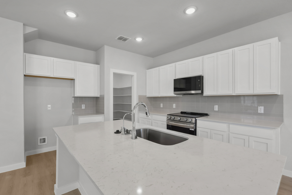 A kitchen with white cabinets.