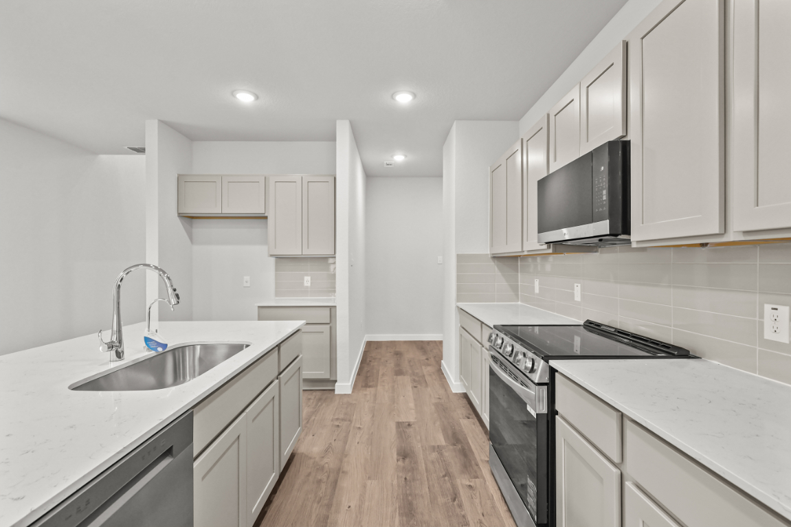 A kitchen with white cabinets.