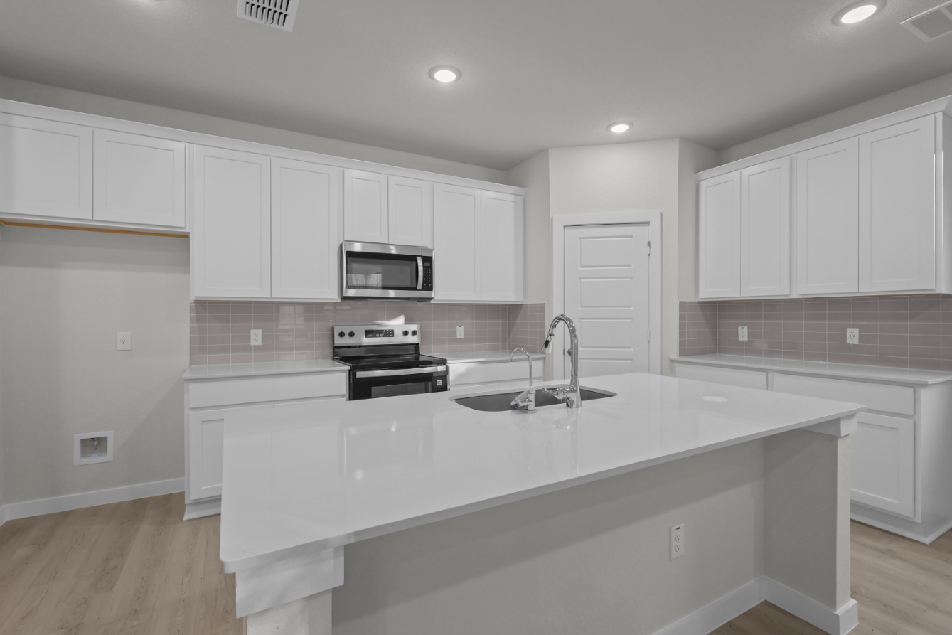 A kitchen with white cabinets.