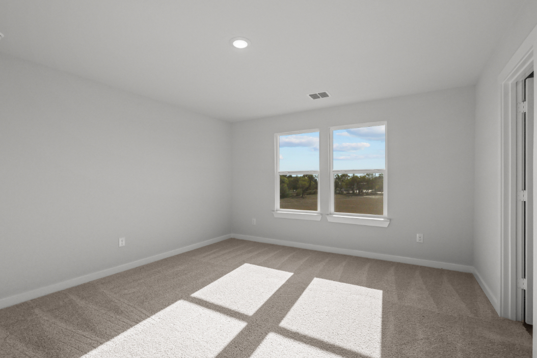 A room with a window and a rug.