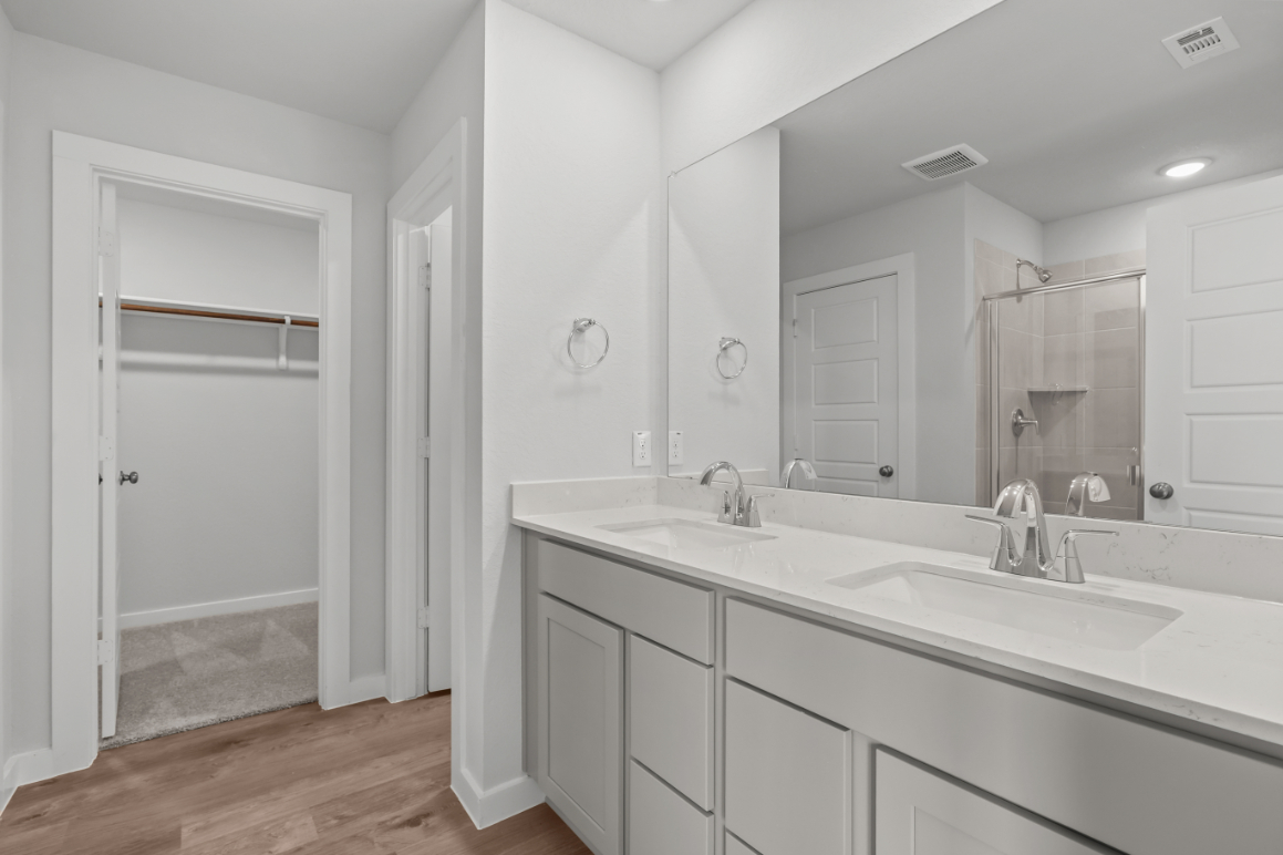 A bathroom with white cabinets.