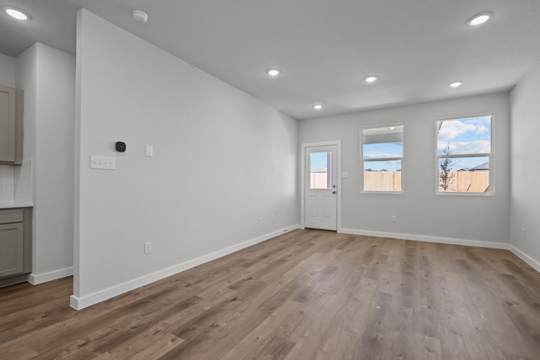 A room with a wood floor and white walls.