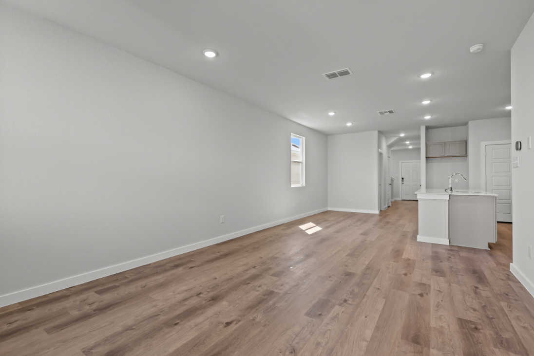 A room with white walls and wood floors.