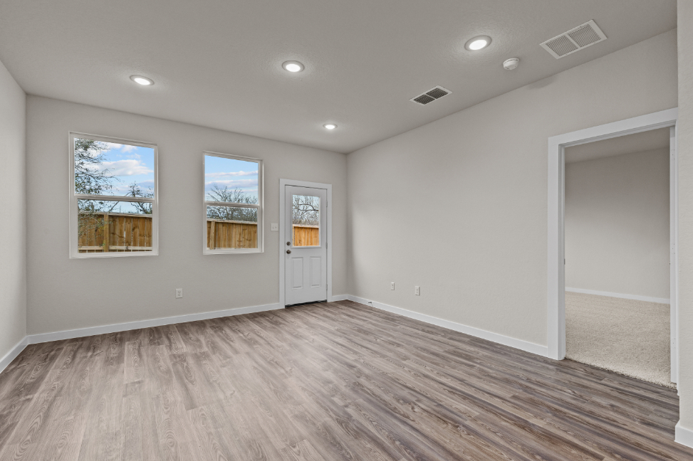 A room with a wood floor and a white door with windows.