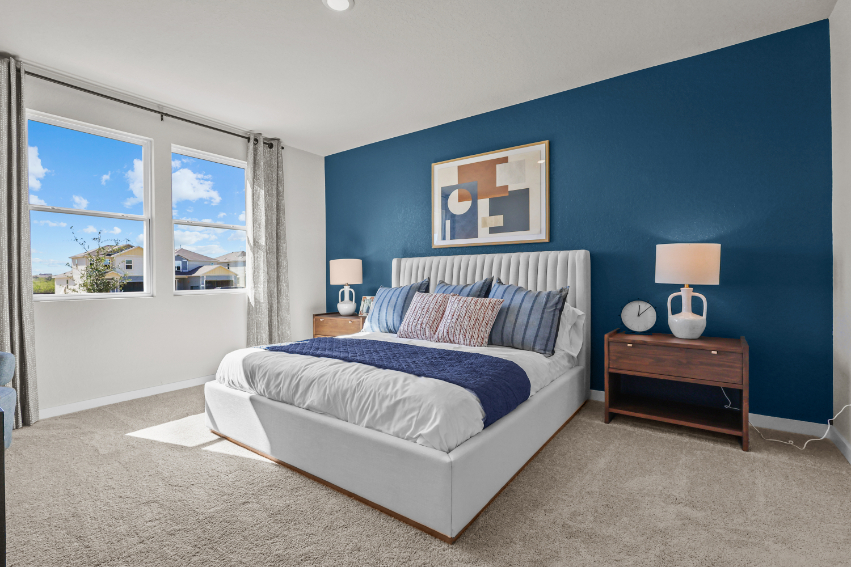 A bedroom with a bed and lamps.