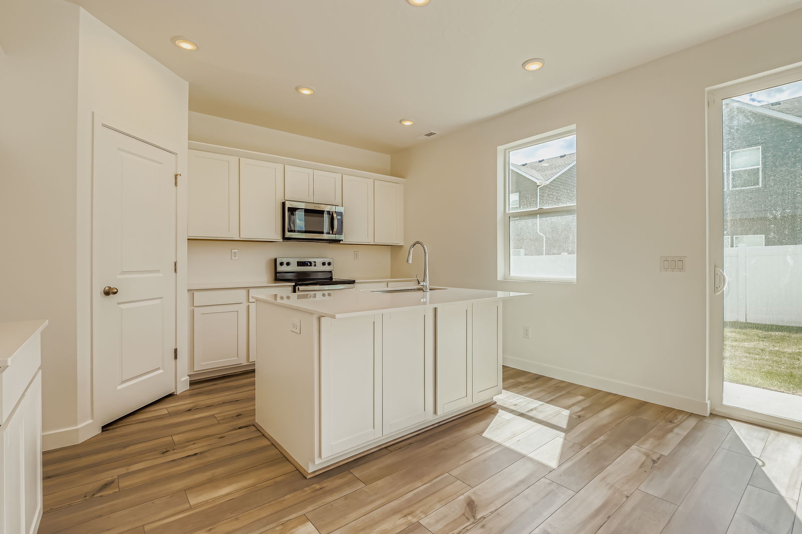 A kitchen with white cabinets.