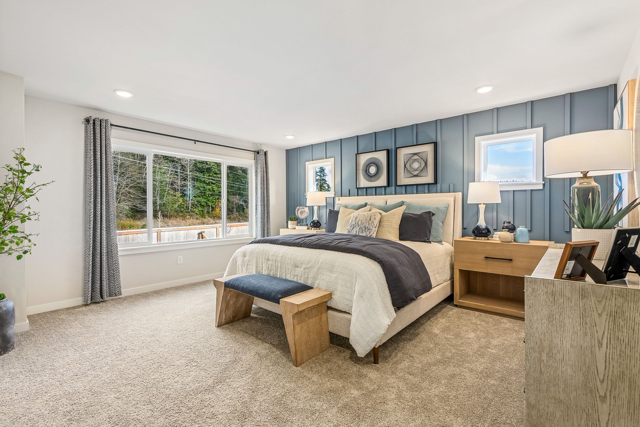 A bedroom with a bed and a bench.