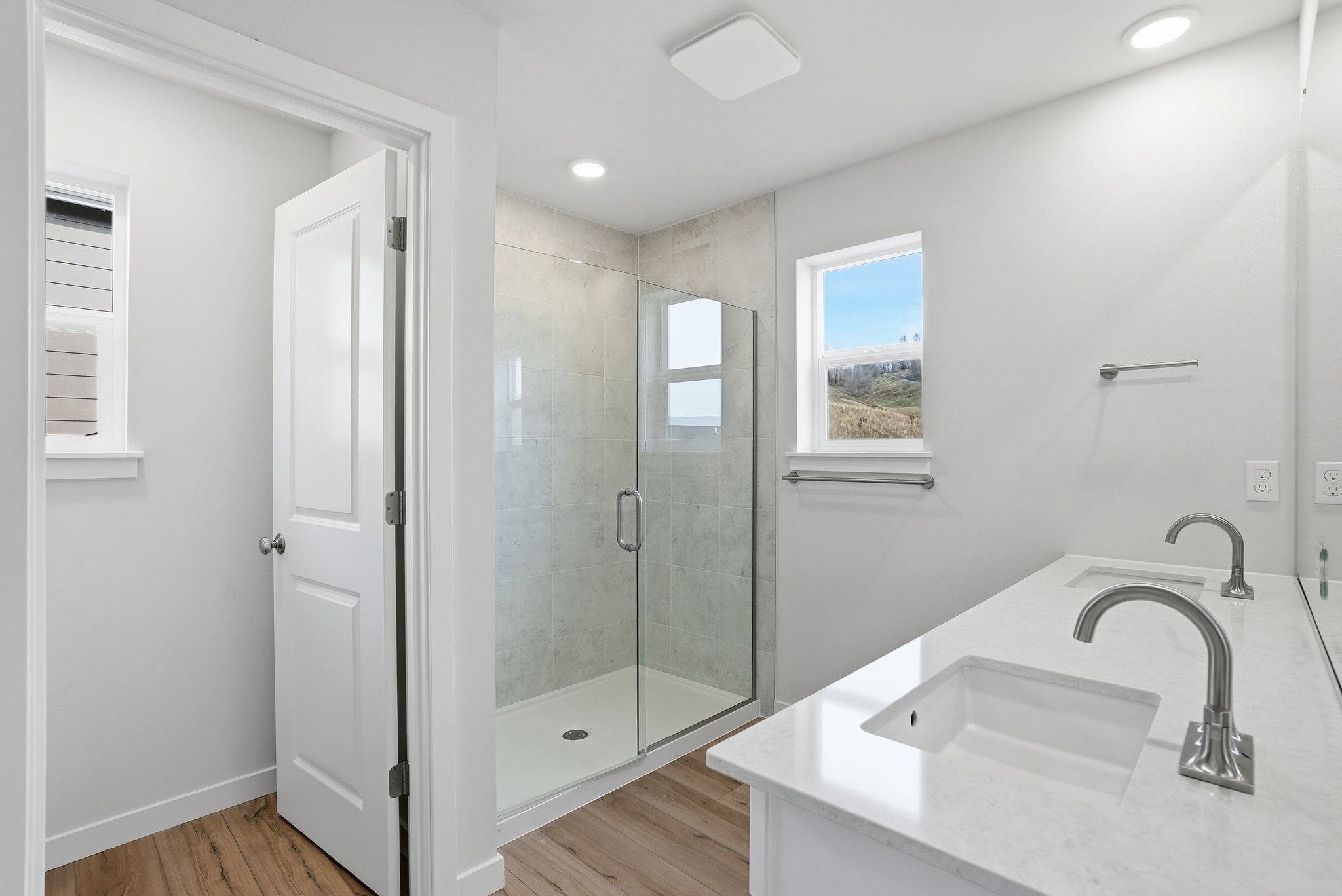 A bathroom with a sink and a shower unit.