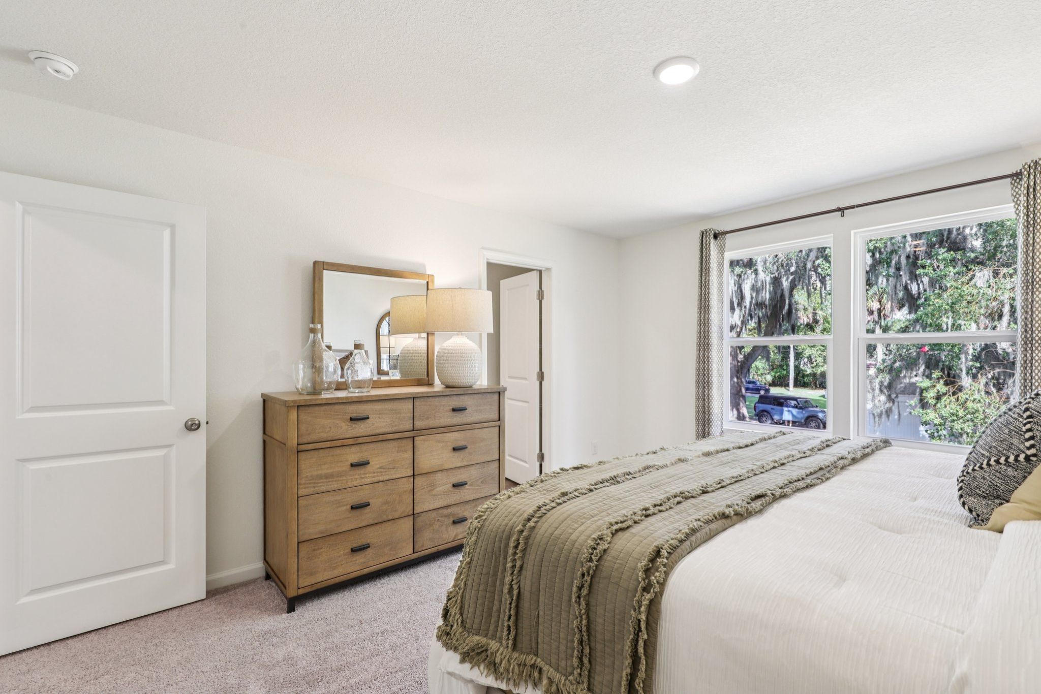 A bedroom with a bed and dresser.
