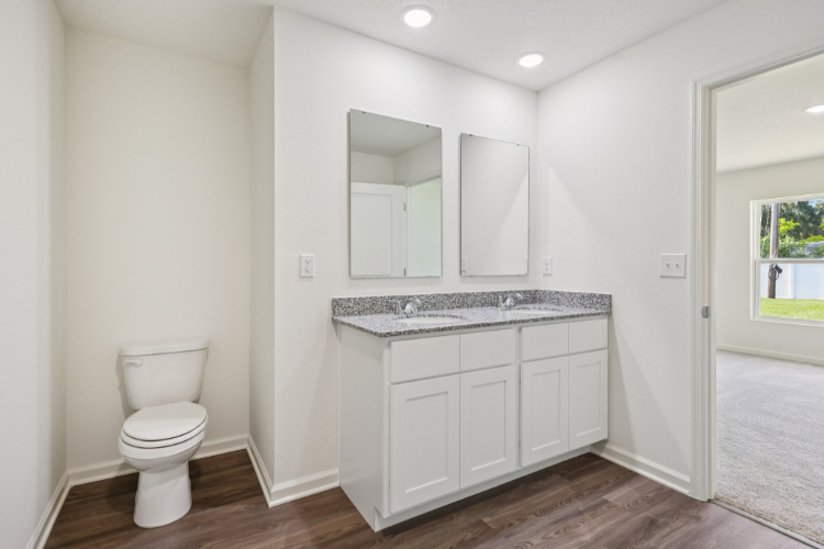A bathroom with white cabinets.