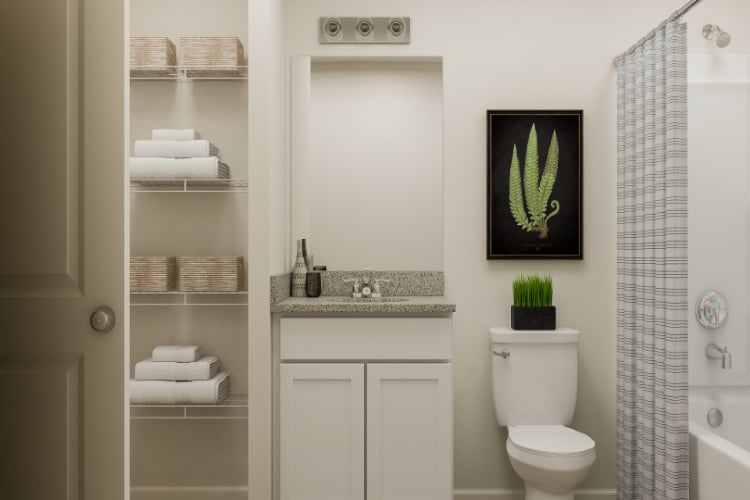 A bathroom with a toilet and a shelf with towels.