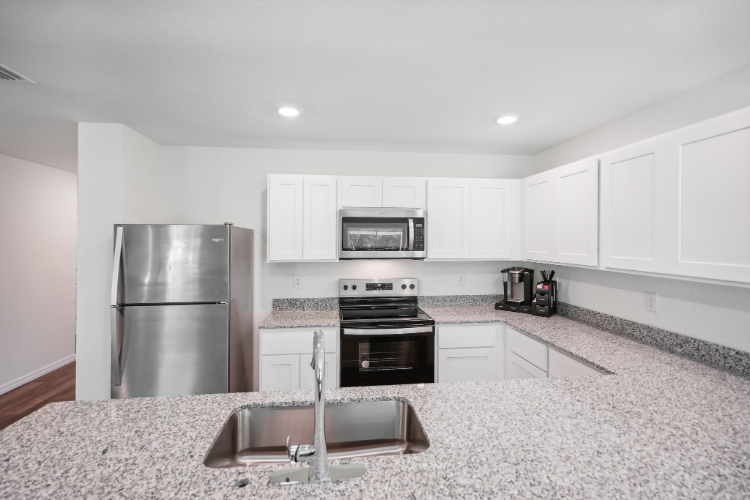 A kitchen with white cabinets.