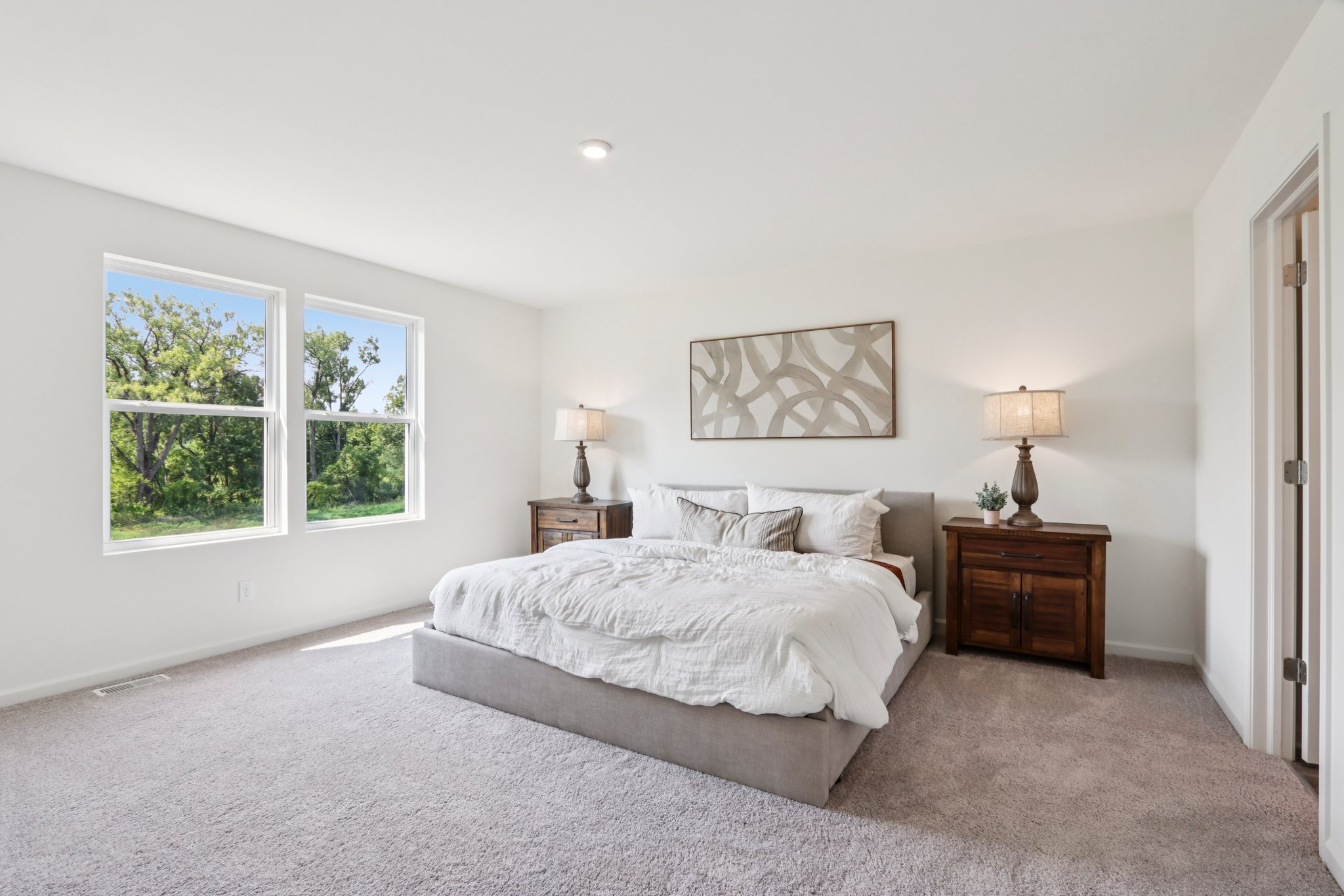 A bedroom with a bed and lamps.