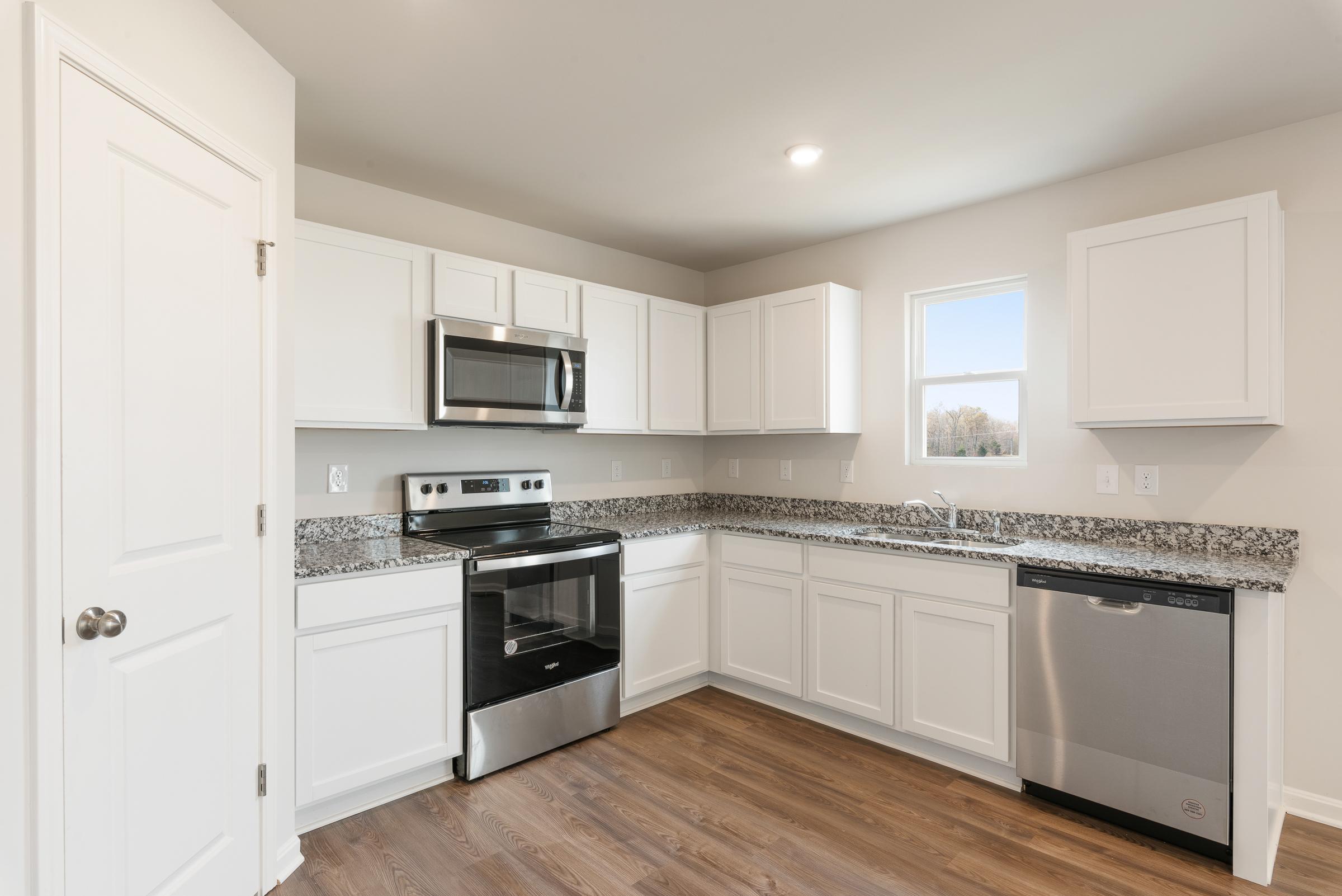 A kitchen with white cabinets.