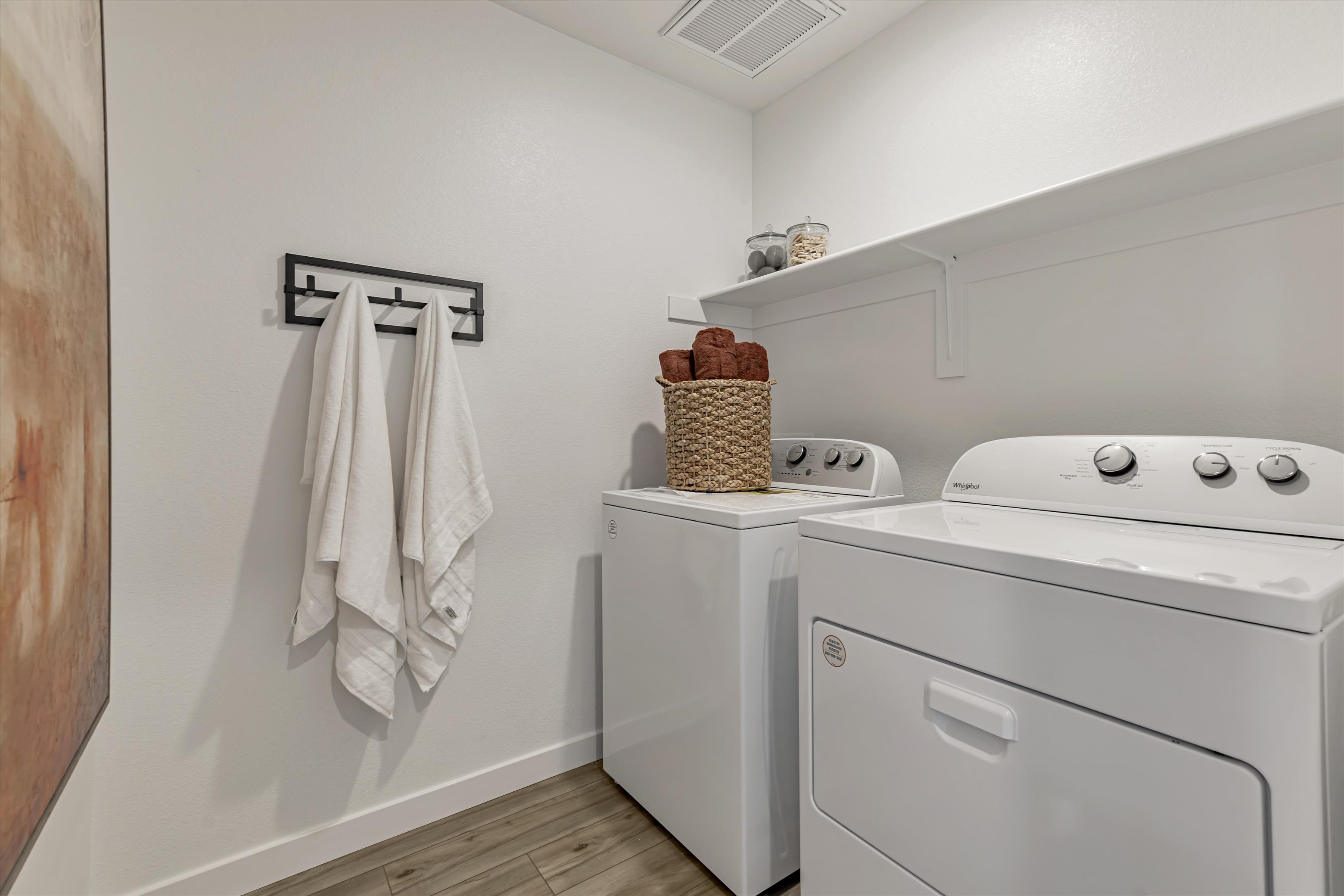 A white kitchen with a basket on the wall.